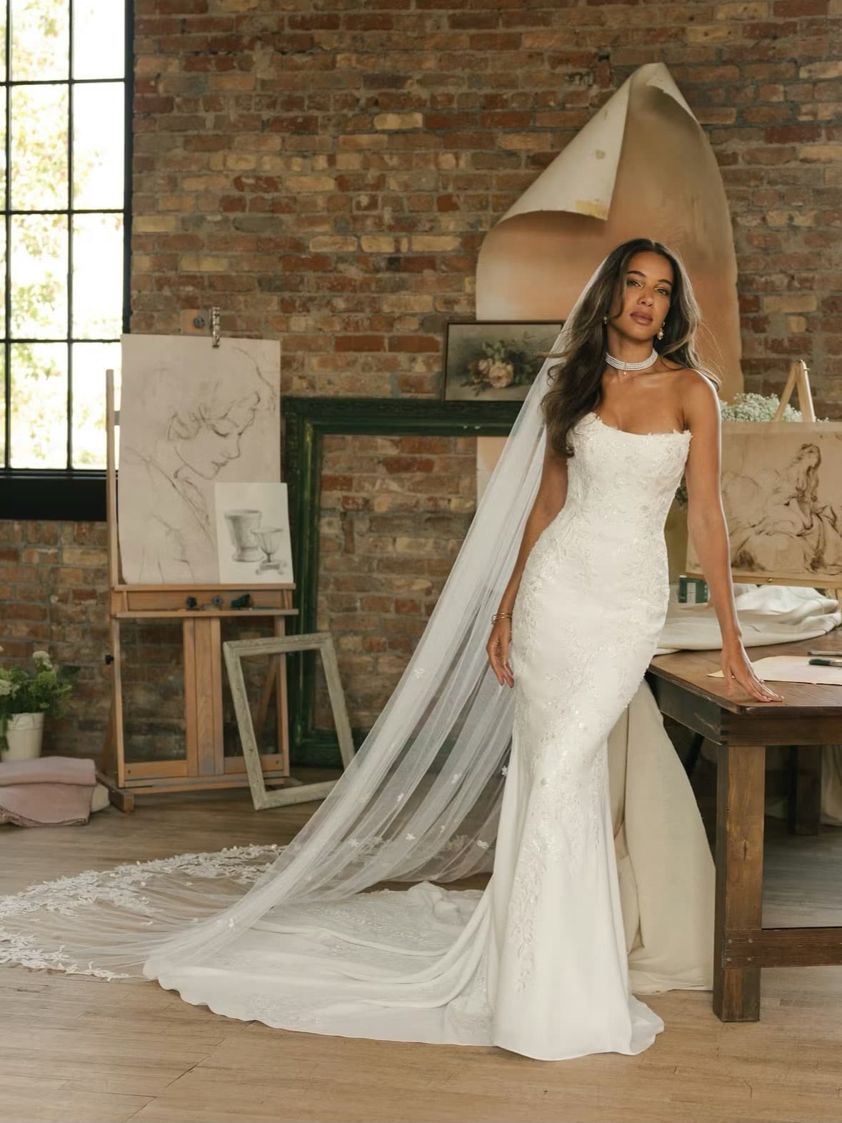 Bride standing in a fitted gown with cathedral veil
